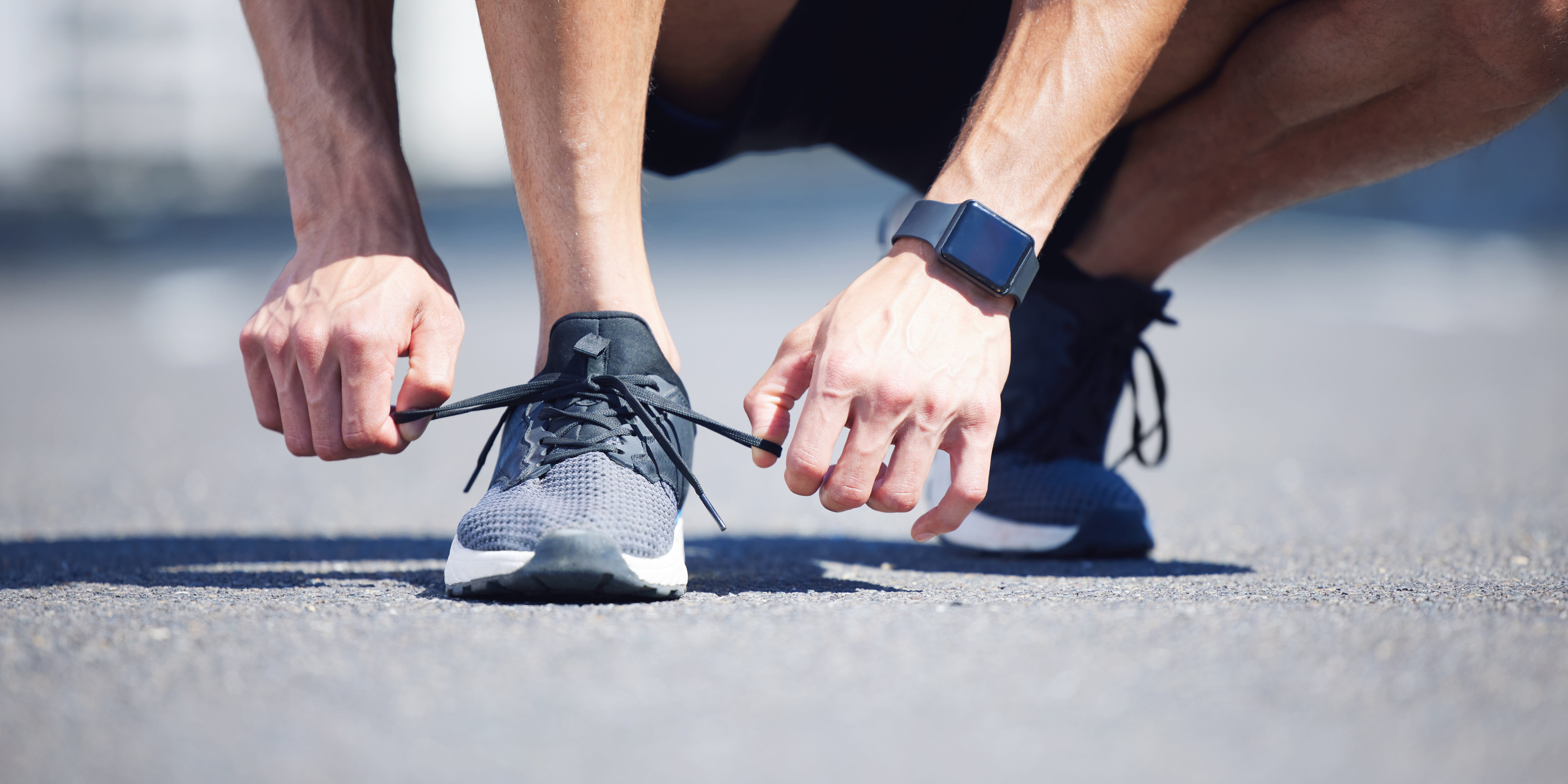 Hands, lace tie or running shoes in city workout, training or marathon exercise for health, wellness or cardio. Zoom, man or sports runner ready for fitness on road or street with digital smart watch