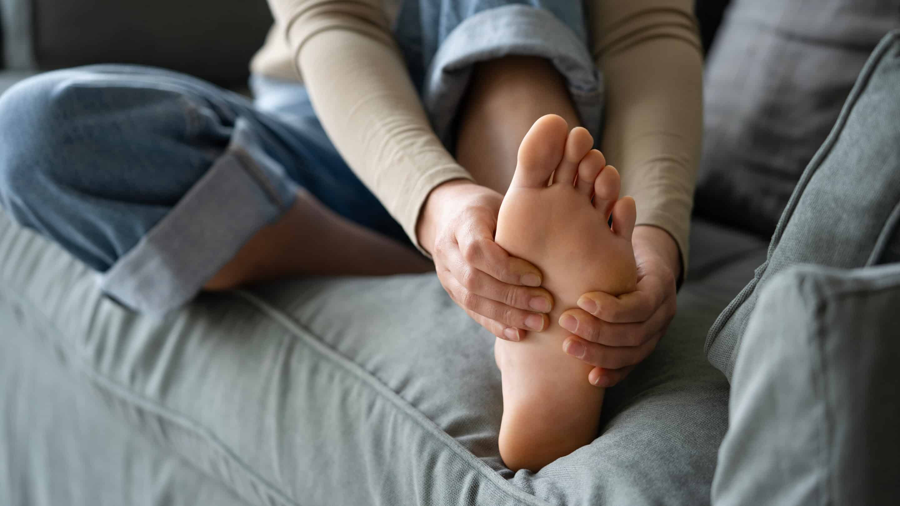 Young woman feeling pain in her foot